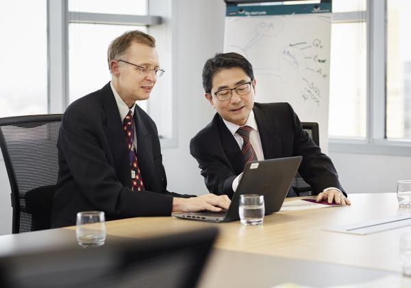 Two men in suits access digital resources