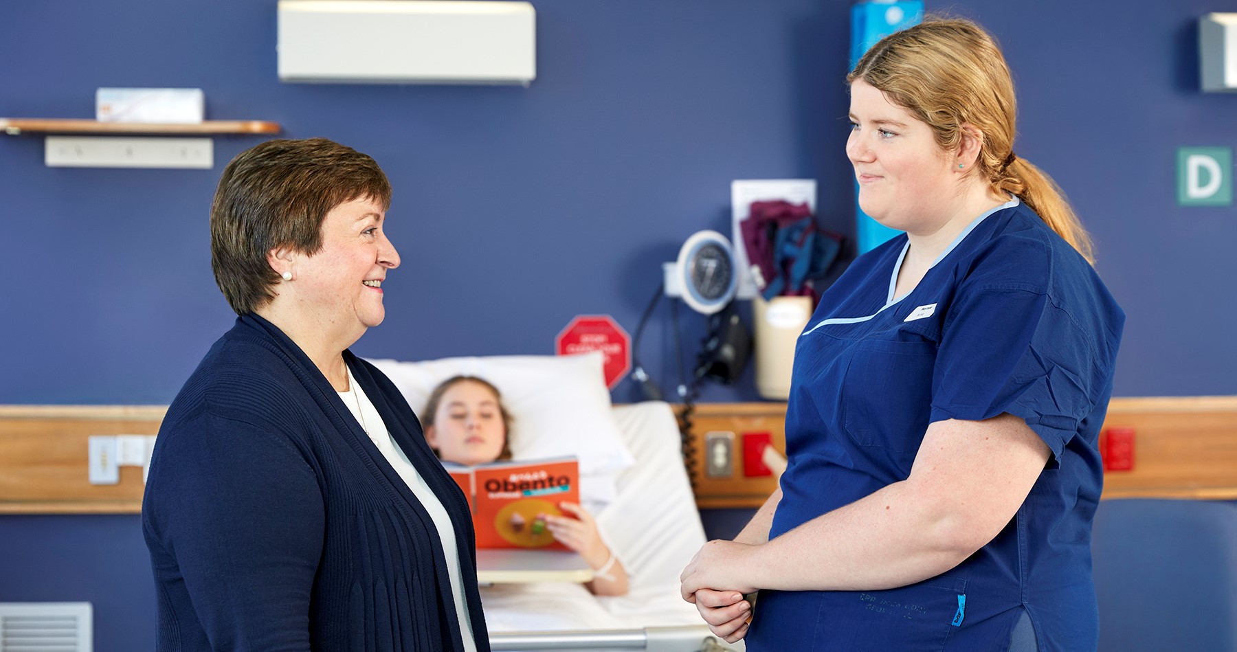 A hospital worker and a woman have a conversation.